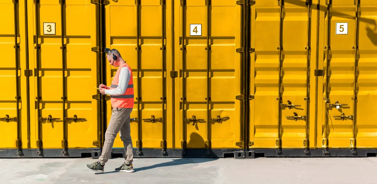 Containers amarillos numerados de Unibox, con una persona que los recorre