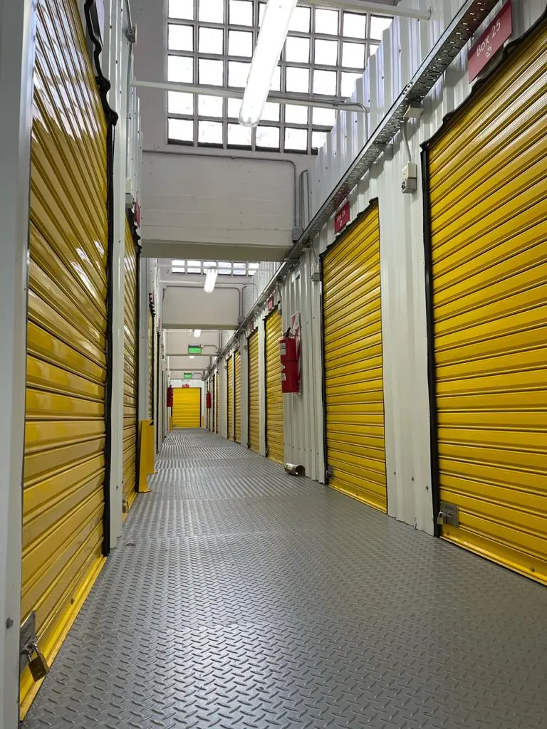 Pasillo de bauleras de Unibox con persianas amarillas y luz cenital